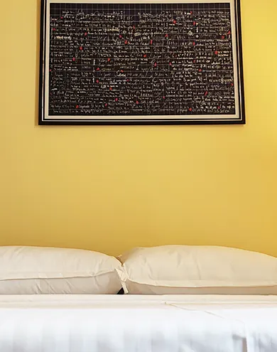 Cozy headboard with cushions and framed 'Je t'aime' artwork, creating a romantic atmosphere