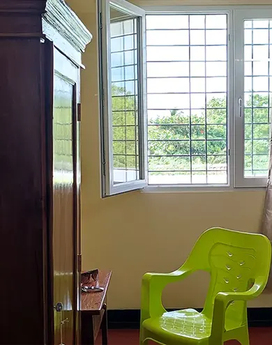 Bright room with green chair and large window overlooking greenery